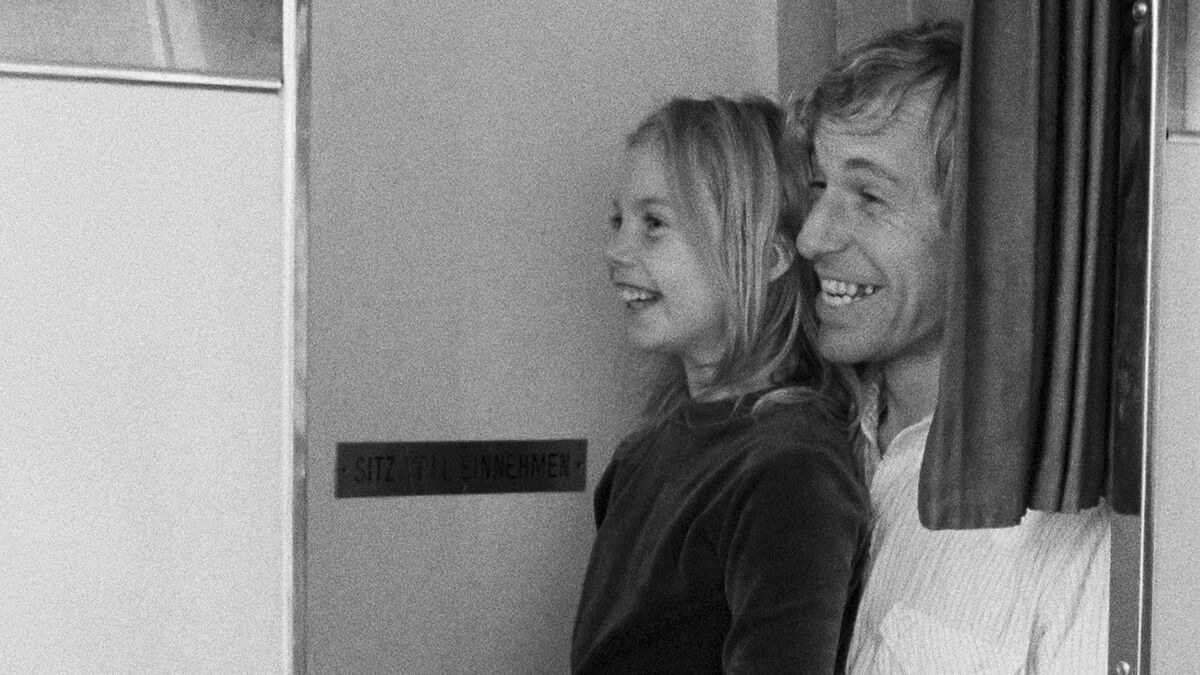 Alice in the Cities — Alice and Philip laughing together in a German train corridor