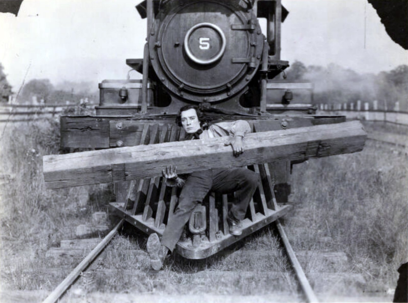 The General — Buster Keaton clinging to the front of the locomotive with a heavy wooden beam across him